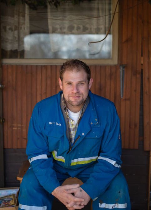 Matt Scott private home buyer is sitting in blue work coveralls on a new home project site